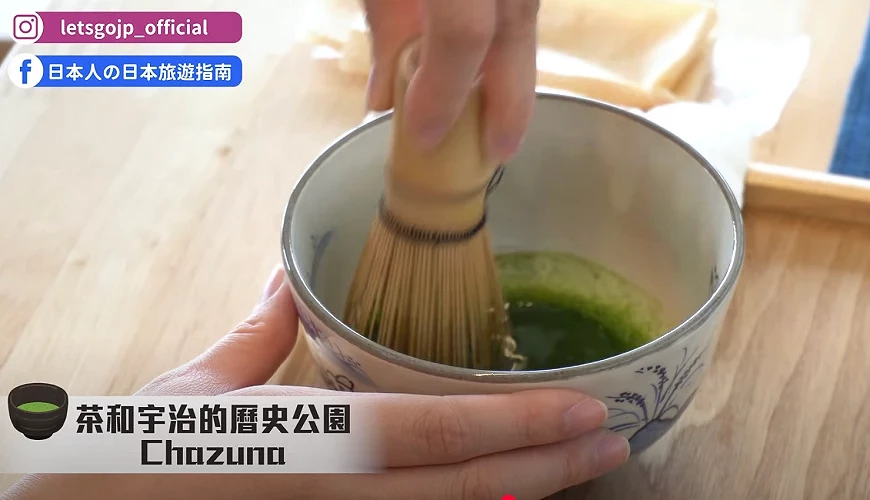 雙手分別握住茶碗與茶筅,在木質桌面上攪拌鮮綠抹茶,畫面左上角顯示Instagram與Facebook社群圖示,下方有「茶和宇治的歷史公園 Chazuna」文字浮水印。